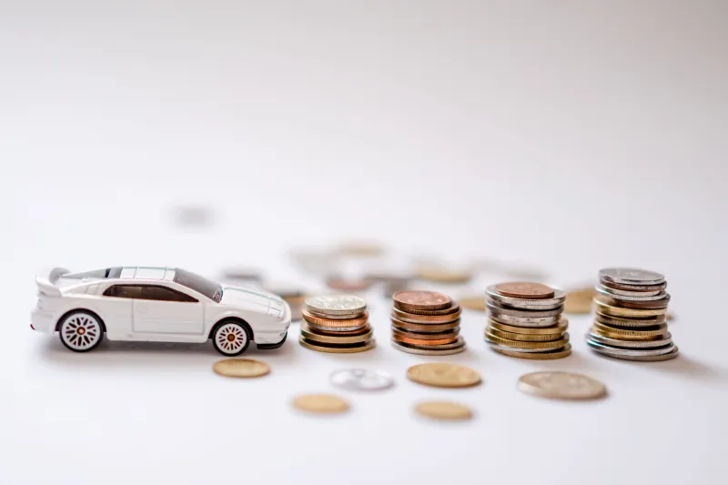 een speelgoed auto met stapeltjes geld
