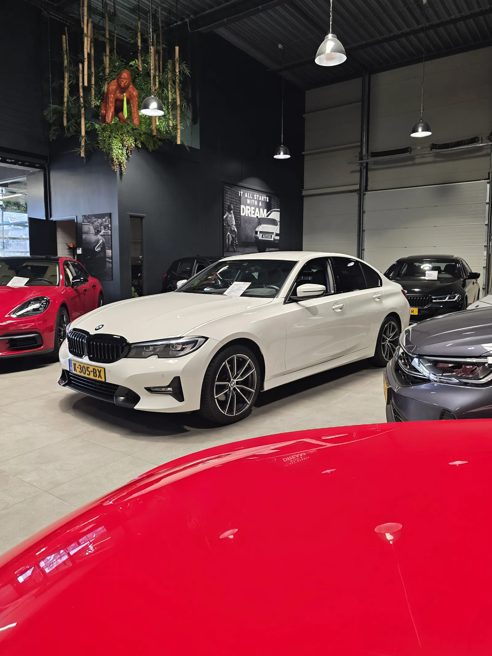 Witte BMW 3 serie omringd door andere glimmende bolides