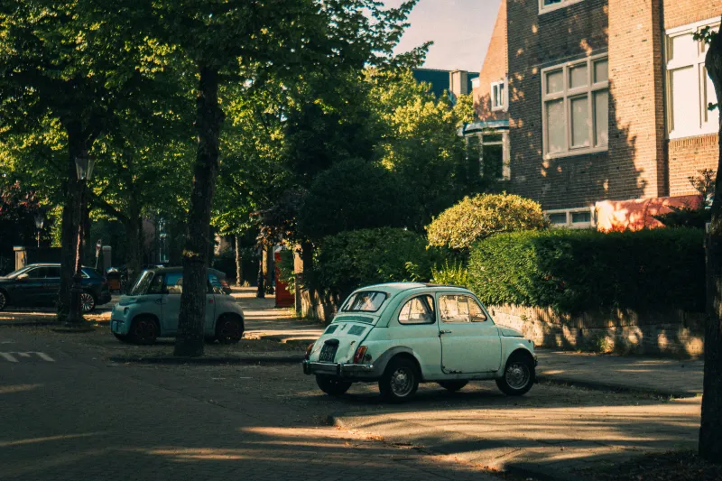 Kleine oldtimer in een straat op een zonnige dag.